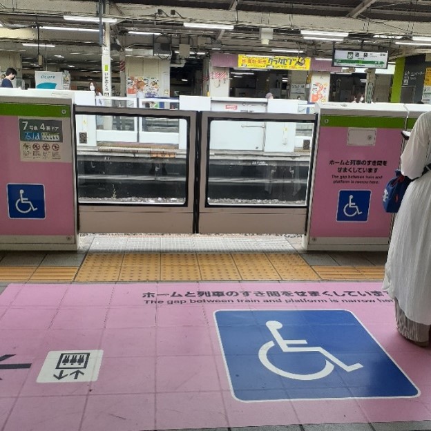 A designated section of a subway platform with accessible features and automatic gates along the ledge of the platform.