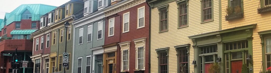 A row of colourful row houses on a city street.