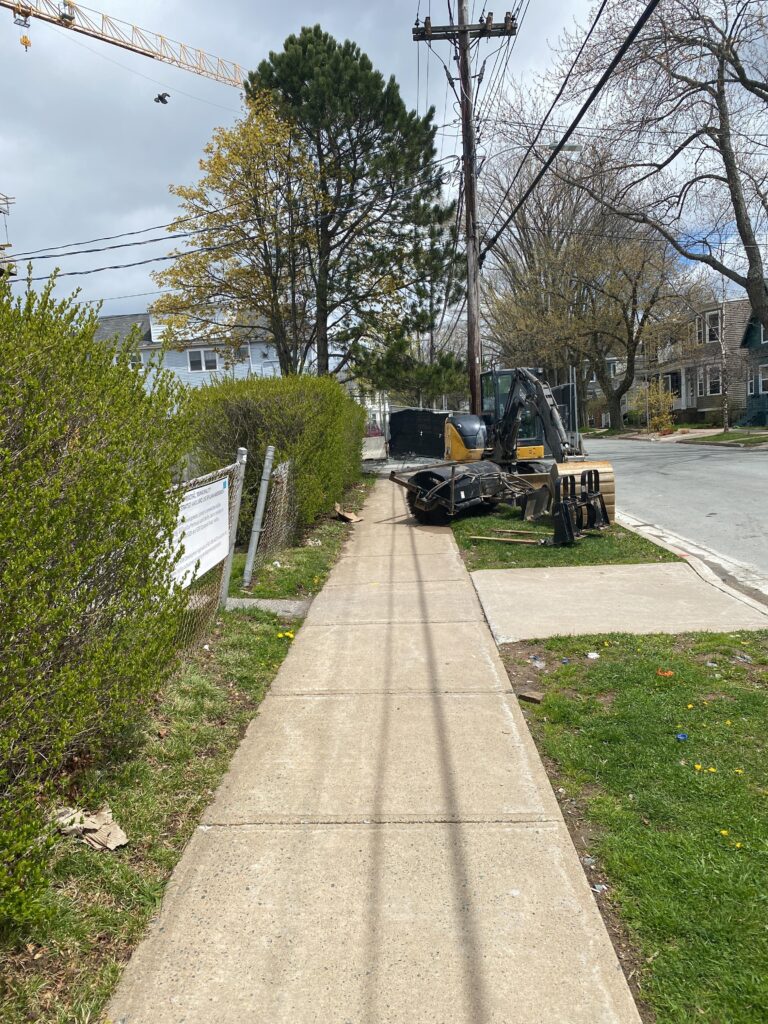 Sidewalk is blocked by construction equipment left in the middle of the sidewalk and on the boulevard.