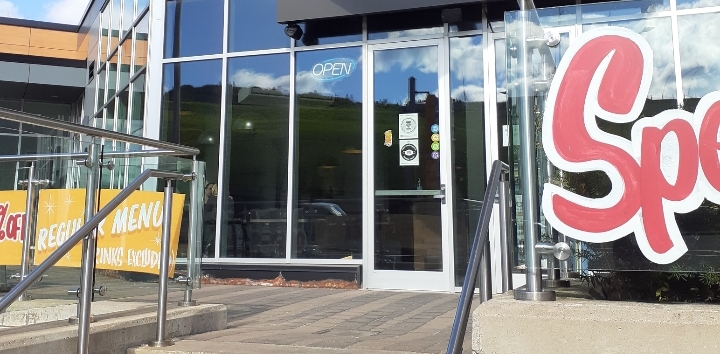 Orso restaurant's front entrance in Downtown Halifax. Four colourful Cheers! To Access badges are stuck to the glass of the restaurant's front door.