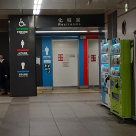 Colourful washroom entrances for male, female, and universally accessible washrooms, with white icons next to entranceway.