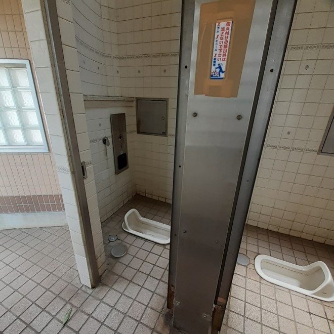 Two washroom stalls with squat-style toilets.