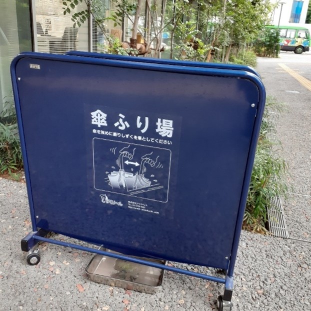 A square, blue plastic taco shell standing outside building doors.