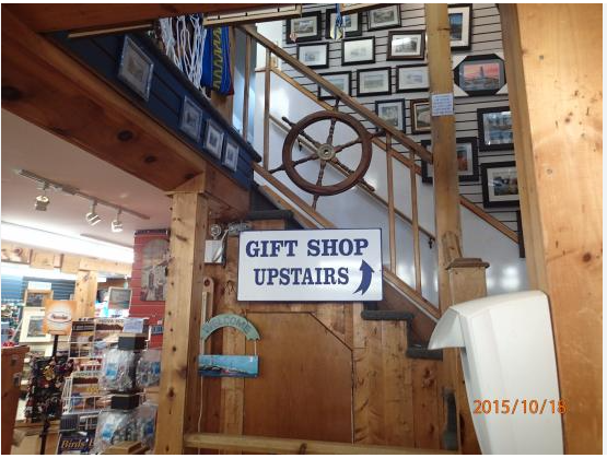 A interior of a gift shop a sign that says, gift shop upstairs.