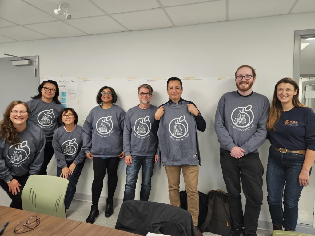 A group of people wearing PEACH branded sweatshirts, celebrating the success of the first workshop